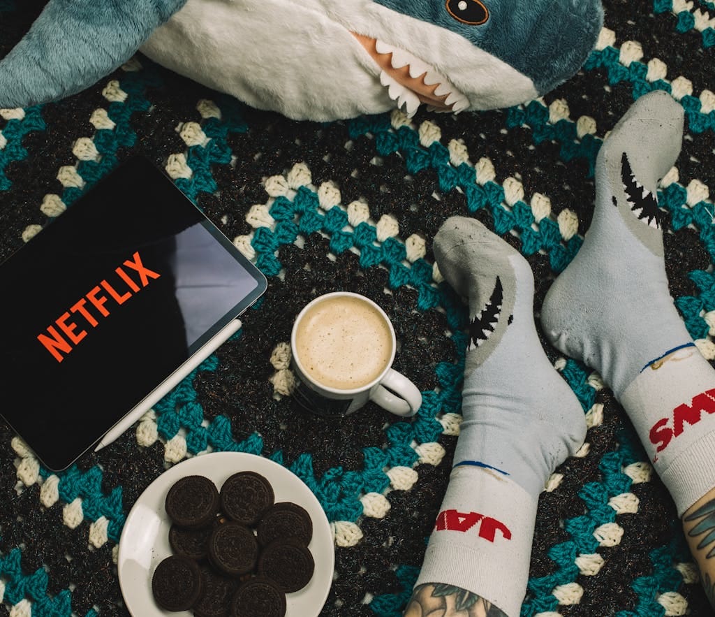 A cozy setup with coffee, cookies, and Netflix for a perfect indoor relaxation day.