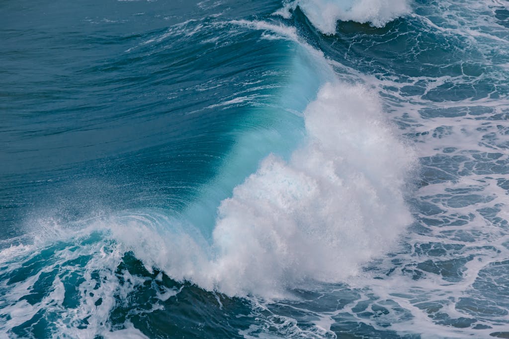 Powerful ocean waves crashing along the scenic shore of Nazaré, Portugal, showcasing nature's raw beauty.