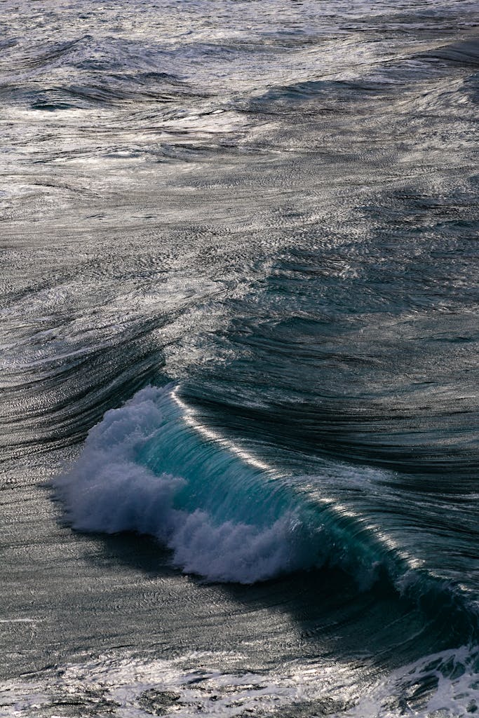 Majestic view of blue sea with rolling waves and foam reflecting sunlight in summer
